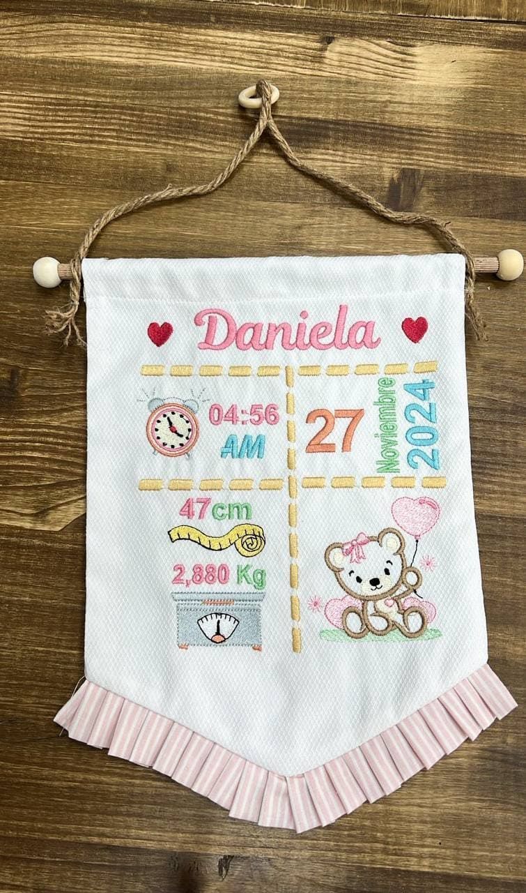 Una pancarta que anuncia el nacimiento de un bebé está colgada en una pared de madera.