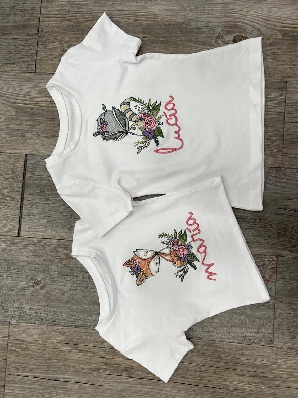 Dos camisas blancas con el nombre Lucía escrito en ellas.