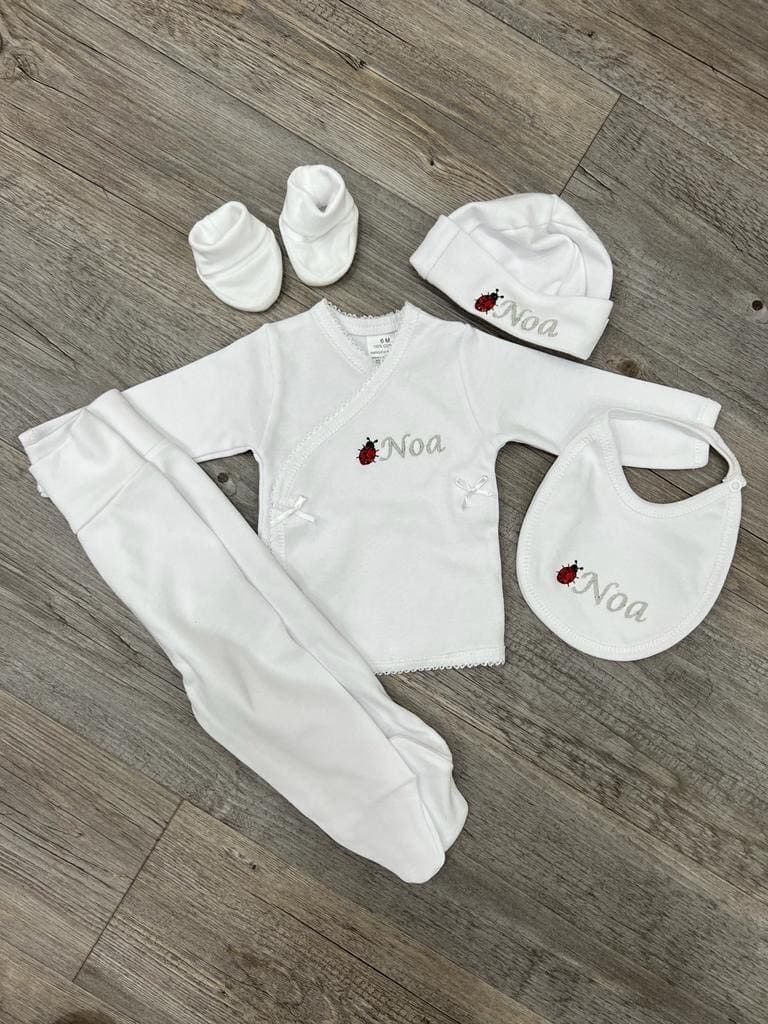 El conjunto de un bebé está sobre un suelo de madera.