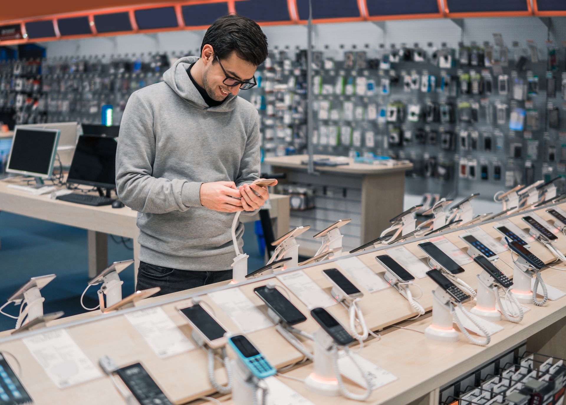 Un homme compare des Smartphones exposés dans un magasin.