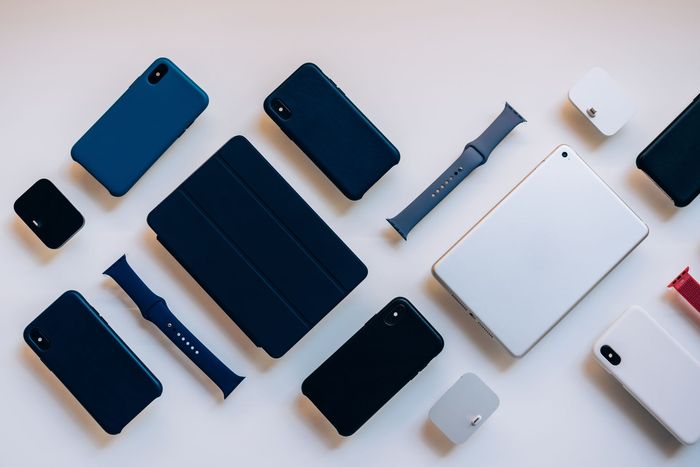 Des Smartphones et des montres connectées de différents types disposés sur un fond clair.