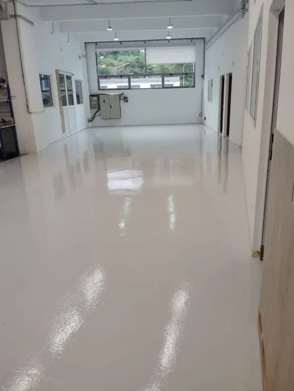 Una habitación grande con suelo blanco y muchas ventanas.