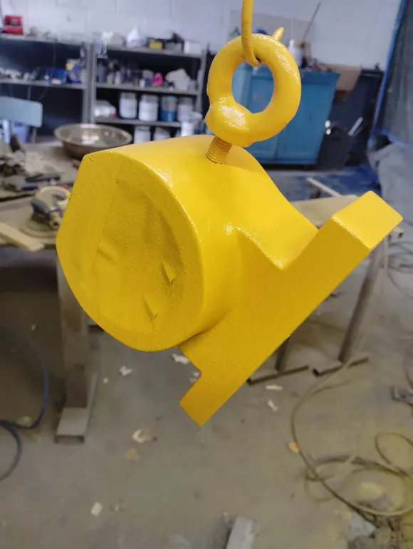 Un objeto amarillo cuelga de un gancho en un taller.