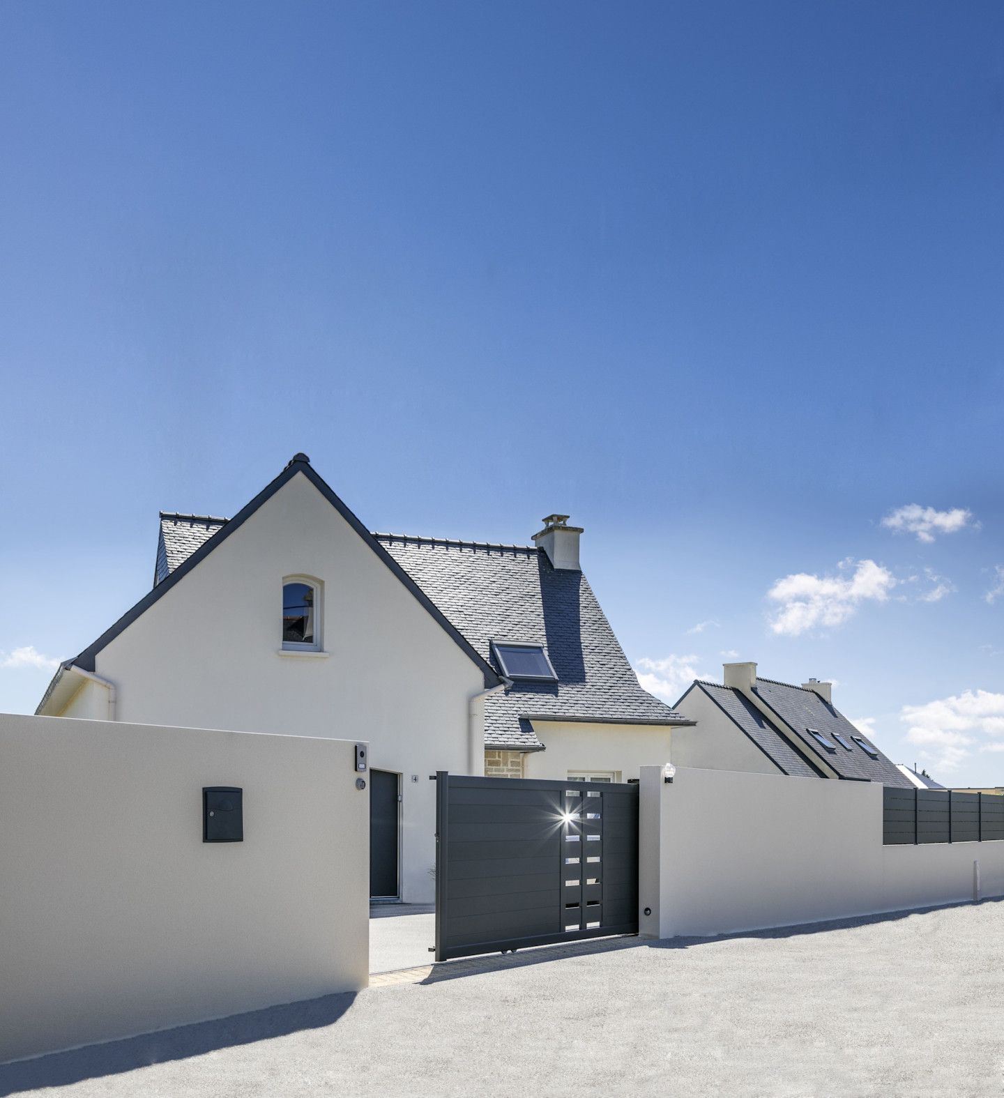 Une façade de maison avec un portail gris rénové