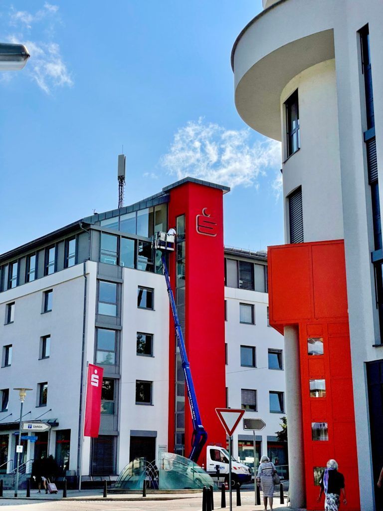 Moderner Gebäudekomplex mit roten und weißen Türmen unter blauem Himmel
