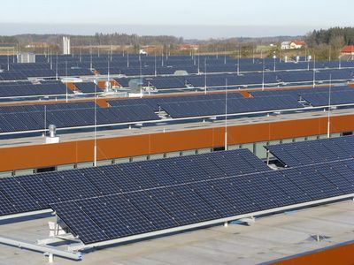 Reihen blauer Solarpaneele auf einem Dach unter klarem Himmel