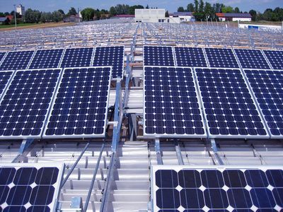Reihen blauer Solarpaneele auf einem Dach im hellen Tageslicht