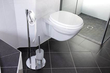Modernes wandhängendes WC mit verchromter Bidetbrause in einem gefliesten Badezimmer