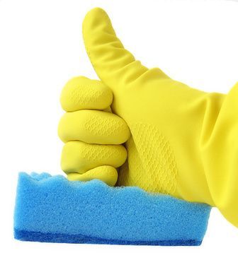 Ein gelber Gummihandschuh hält einen blauen Schwamm und zeigt eine Reinigungsgeste.