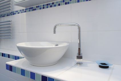 Modernes weißes Badezimmerwaschbecken mit Chromarmatur und blauen Fliesenakzenten