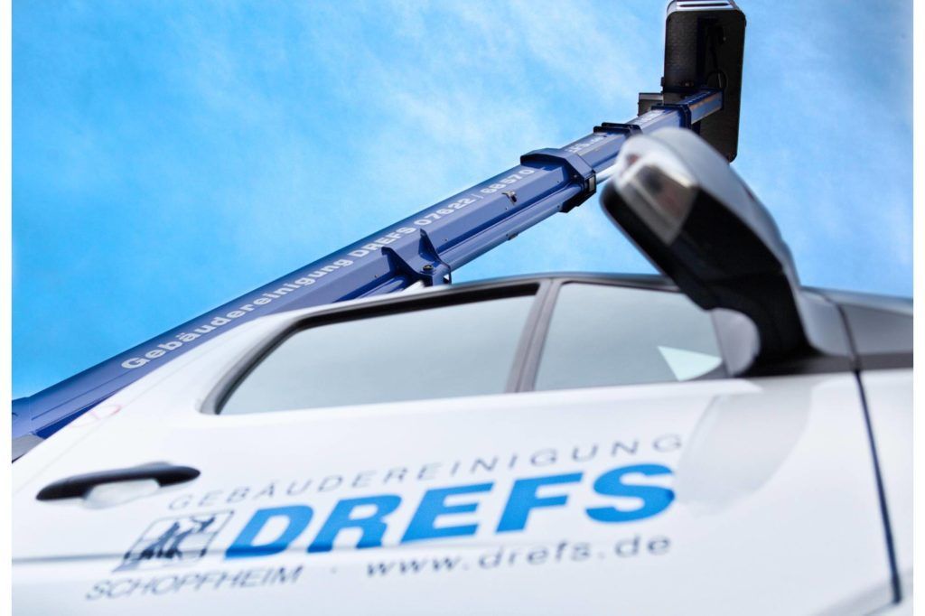 Weißes Fahrzeug mit einem auf dem Dach montierten mechanischen Arm und dem blauen „JUNGDREFS“-Logo an der Seite.