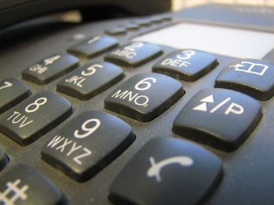 Nahaufnahme einer schwarzen Telefontastatur mit erhabenen weißen Ziffern und Buchstaben