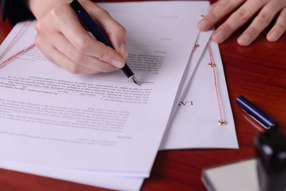 Une personne écrivant sur une feuille.