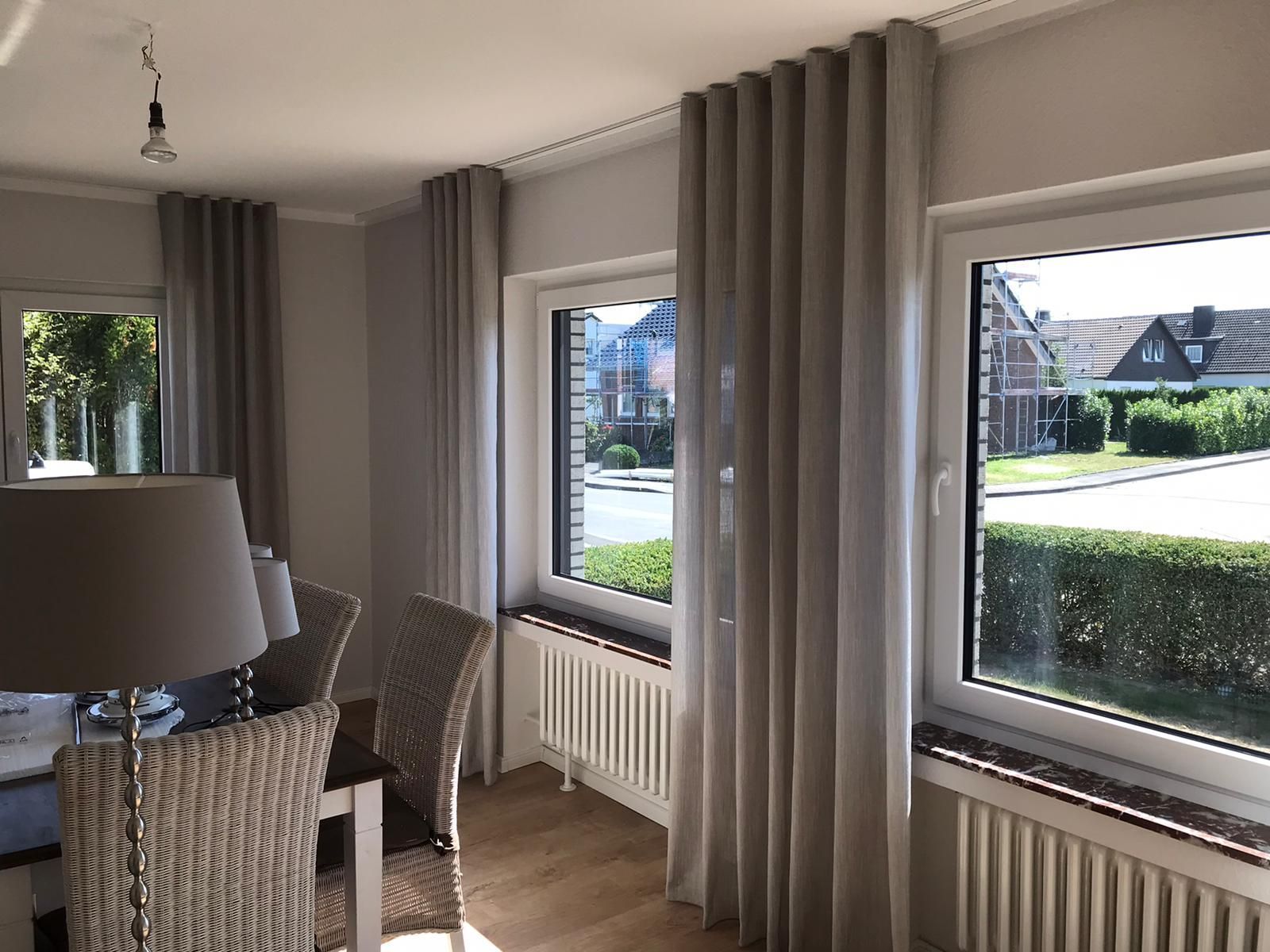 Ein Wohnzimmer mit Tisch und Stühlen und einem großen Fenster.