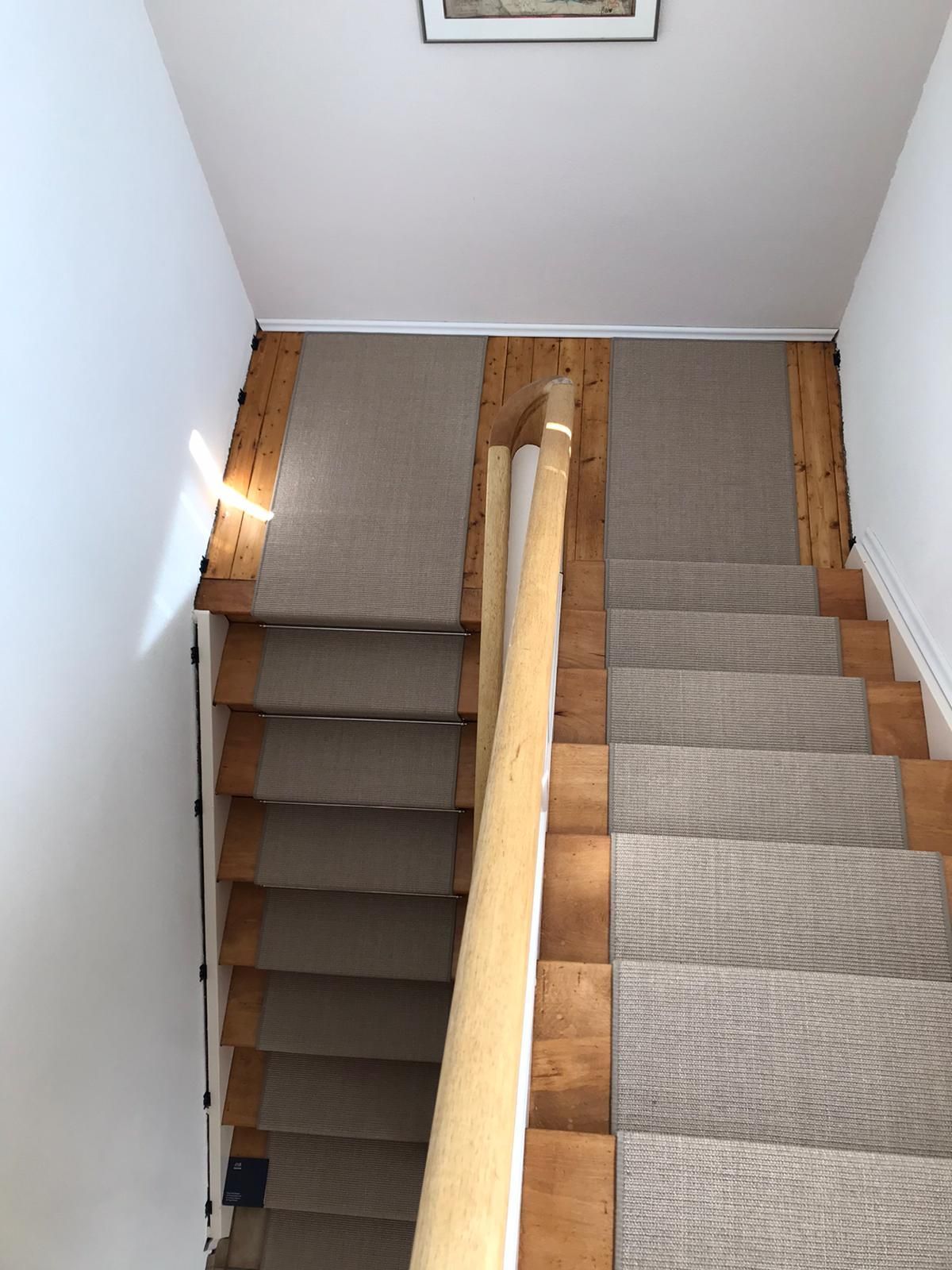 Eine Treppe mit einem Teppich auf den Stufen und einem Holzgeländer