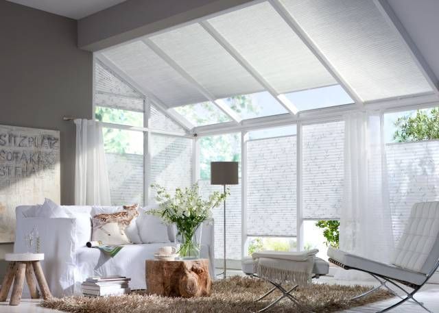 Ein Wohnzimmer mit Couch, Sessel, Tisch und Teppich