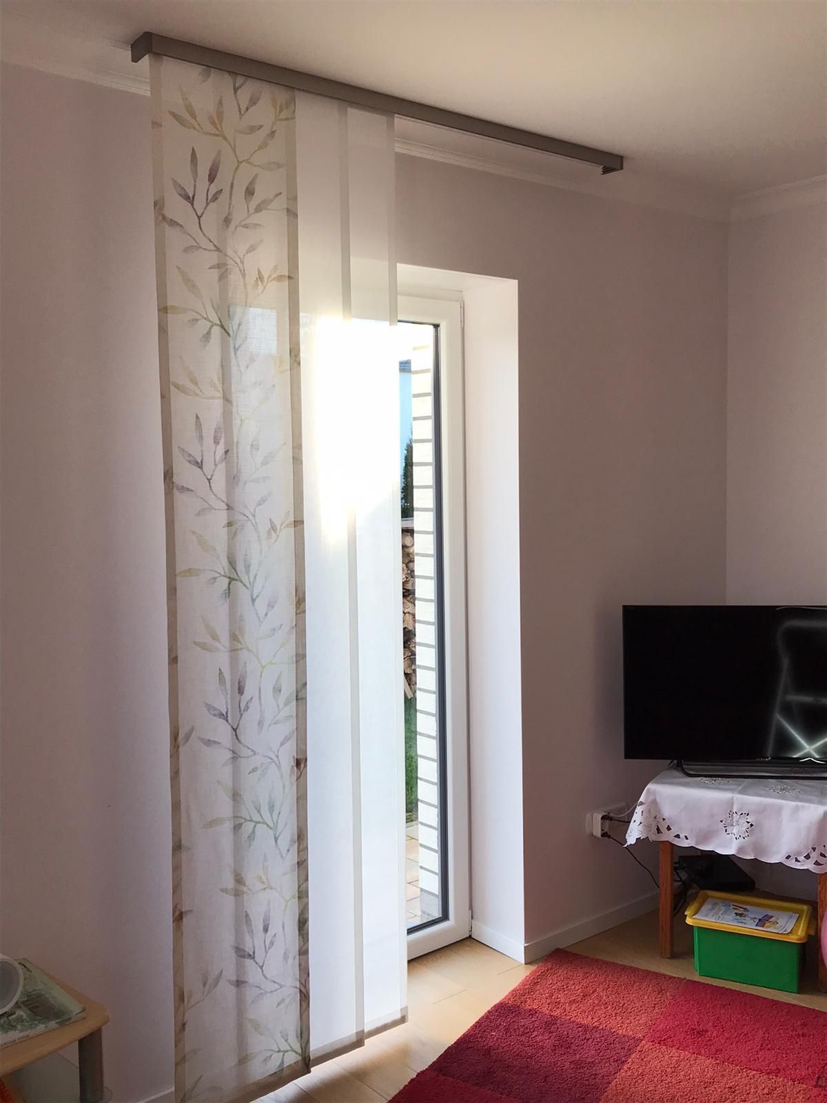 Ein Wohnzimmer mit Glasschiebetür und Flachbildfernseher.