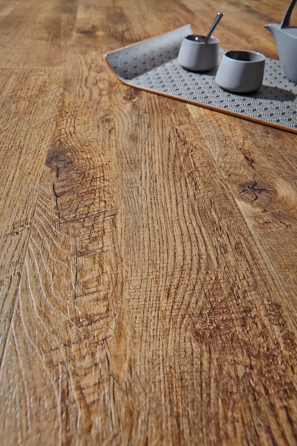 Ein Holztisch mit zwei Tassen und einer Teekanne darauf.