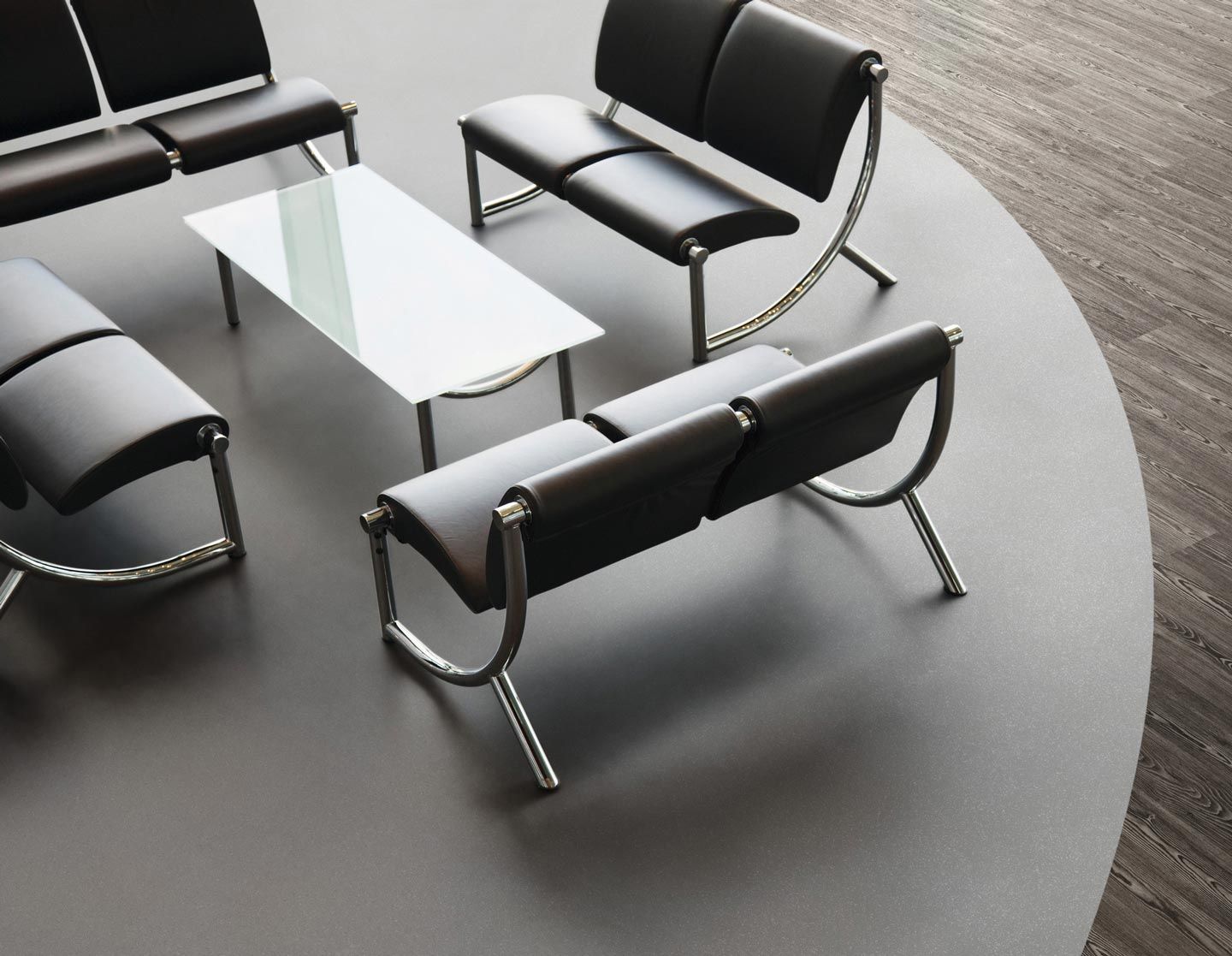 Ein Wartezimmer mit schwarzen Stühlen und einem weißen Tisch