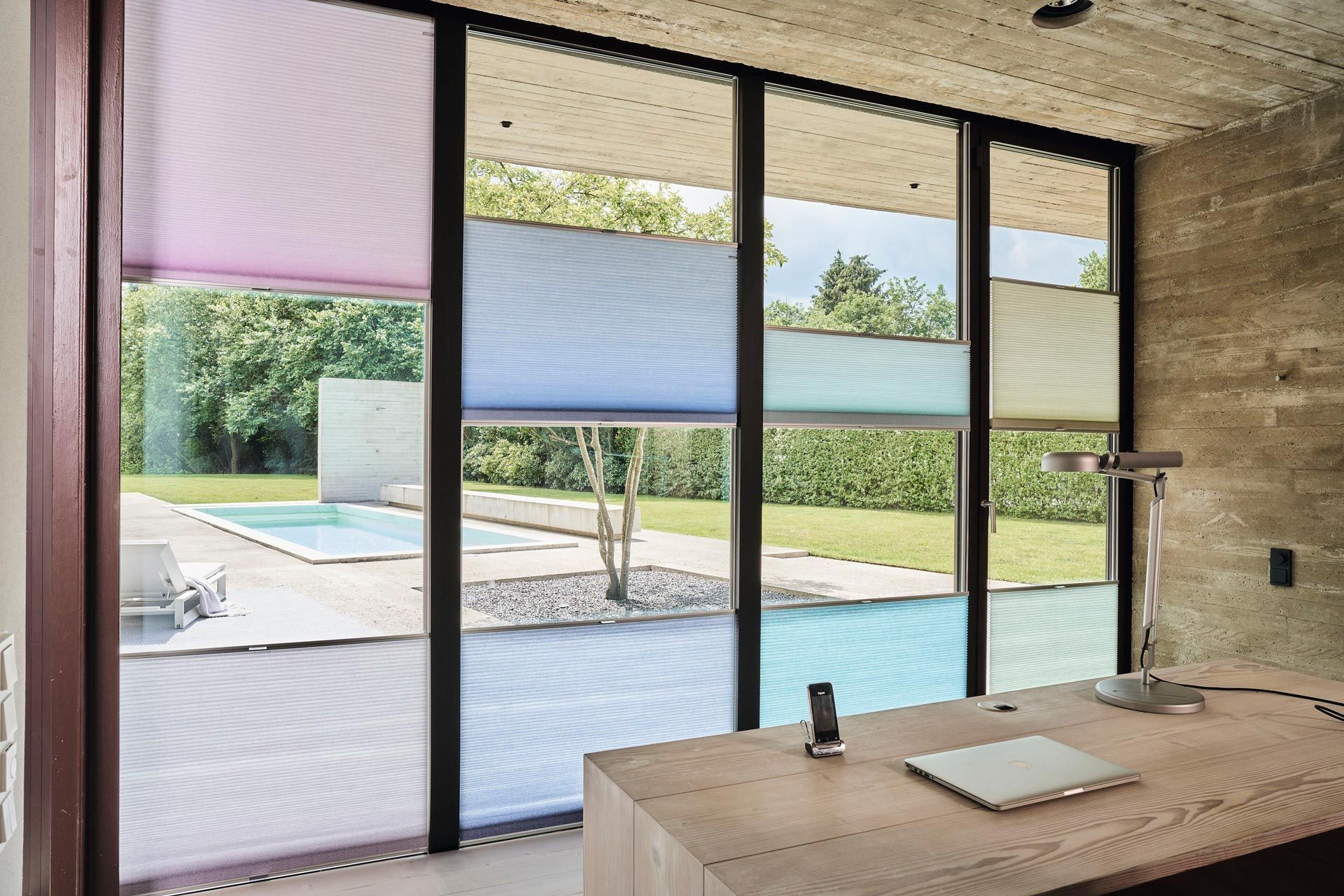 Ein Schreibtisch vor einem Fenster mit einem Laptop darauf