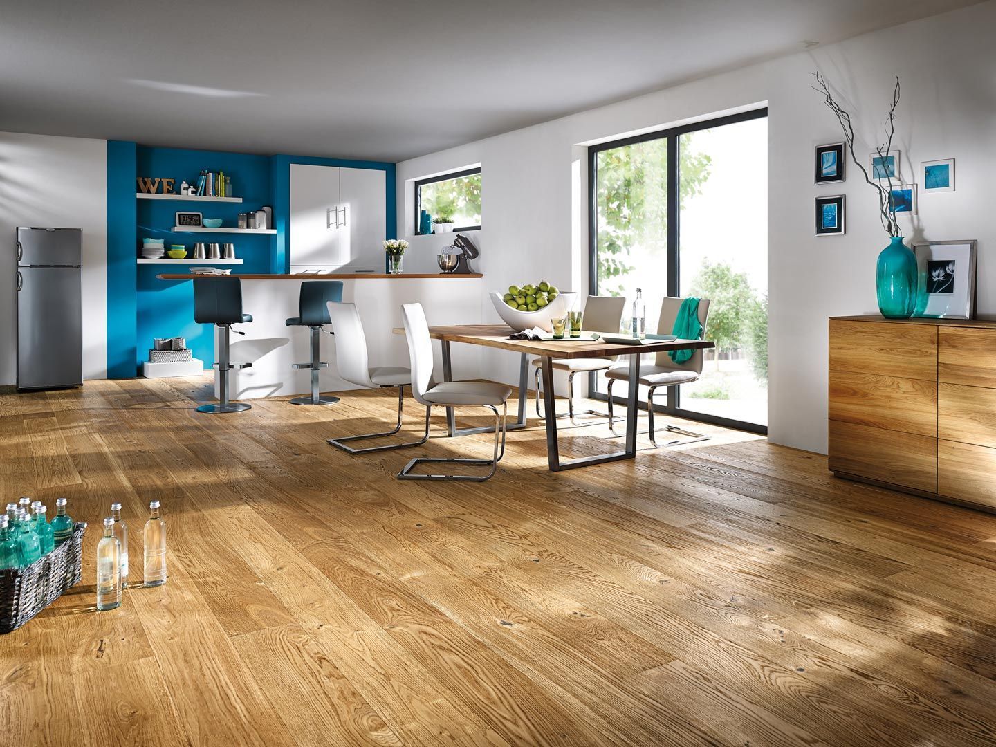 Ein Esszimmer mit einem Holztisch und Stühlen und einem Kühlschrank.