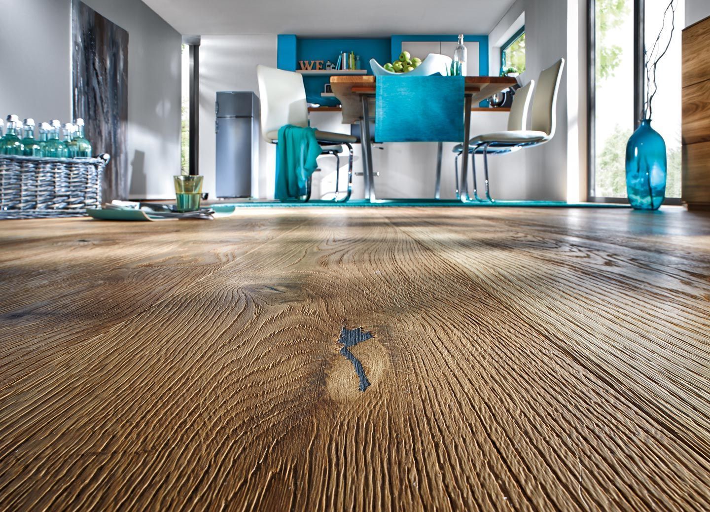 Ein Esszimmer mit Holzboden und blauen Stühlen