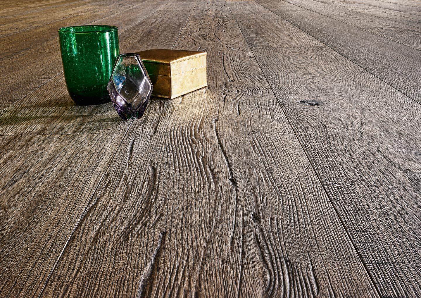 Ein Holzboden mit einem Buch und einem Glas darauf.