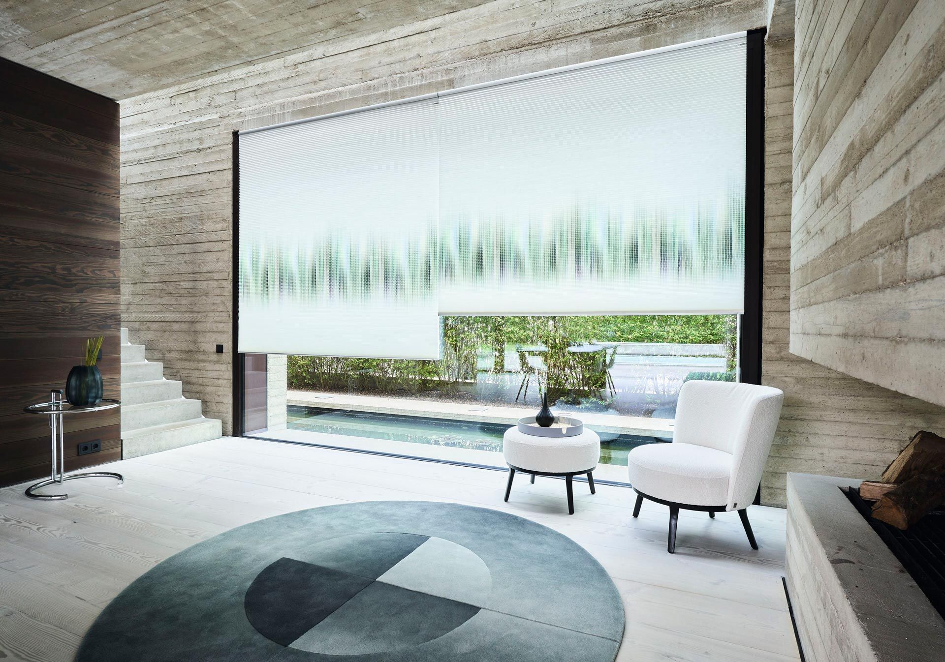 Ein Wohnzimmer mit einem großen Fenster, einem Stuhl, einem Tisch und einem Teppich.