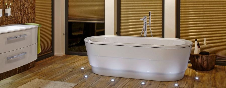 Ein Badezimmer mit Badewanne und Kerzen auf dem Boden.