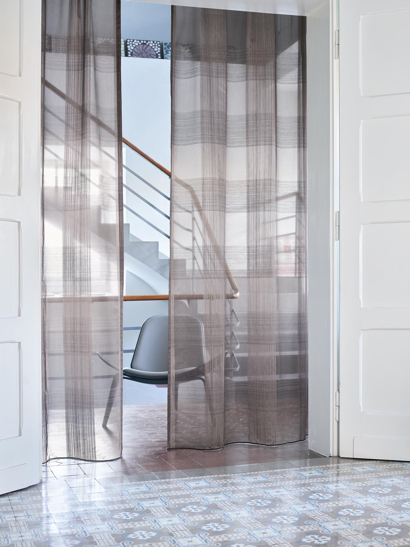 Ein Raum mit einem Stuhl und einer Treppe hinter einem Vorhang