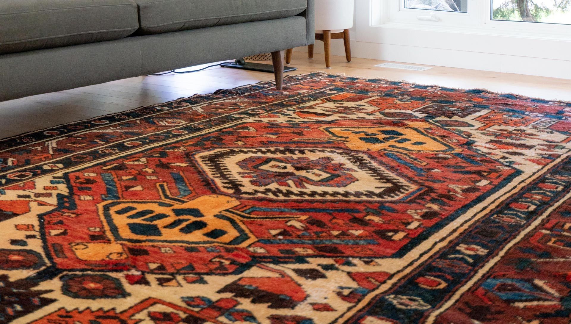 Ein Wohnzimmer mit einer Couch und einem Teppich auf dem Boden.