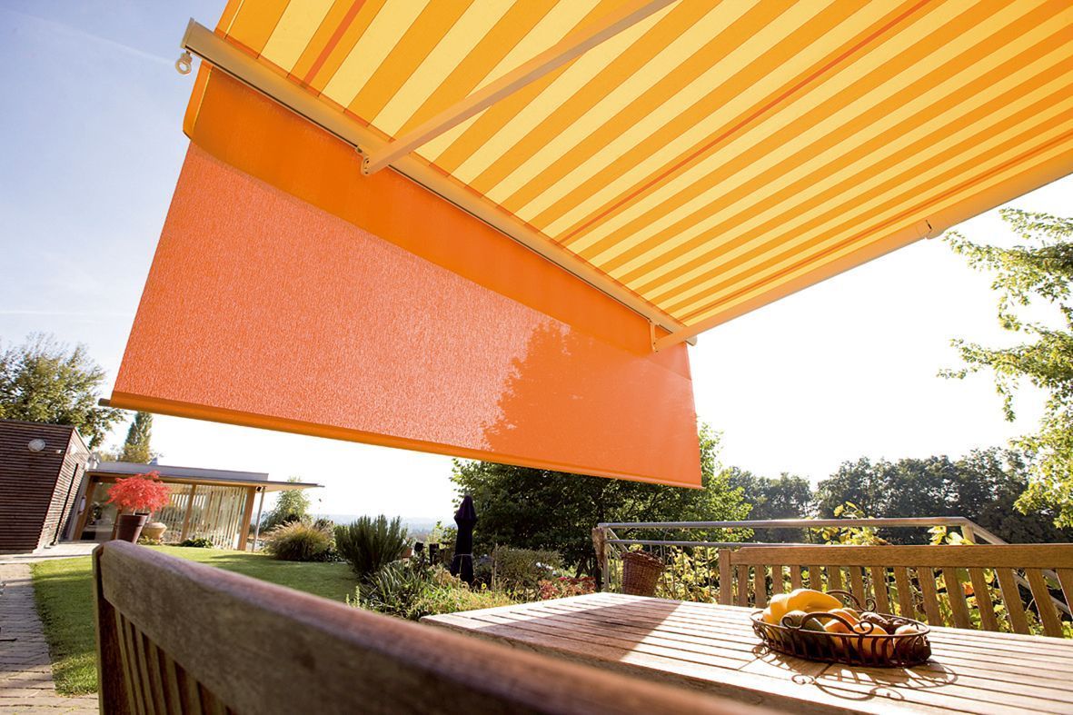 Ein Tisch mit einer gelb-weiß gestreiften Markise darüber