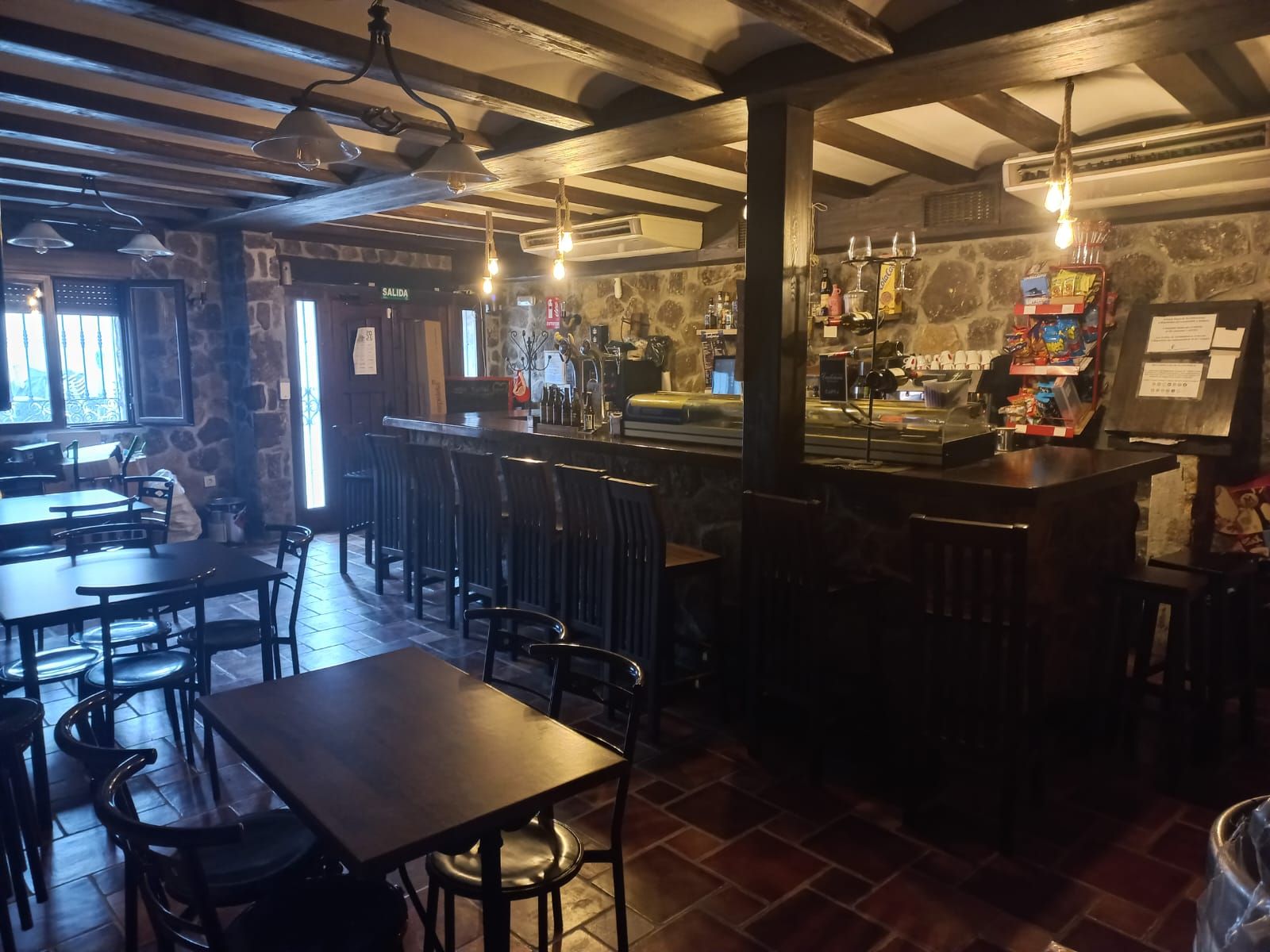 Un restaurante con mesas y sillas y un bar.