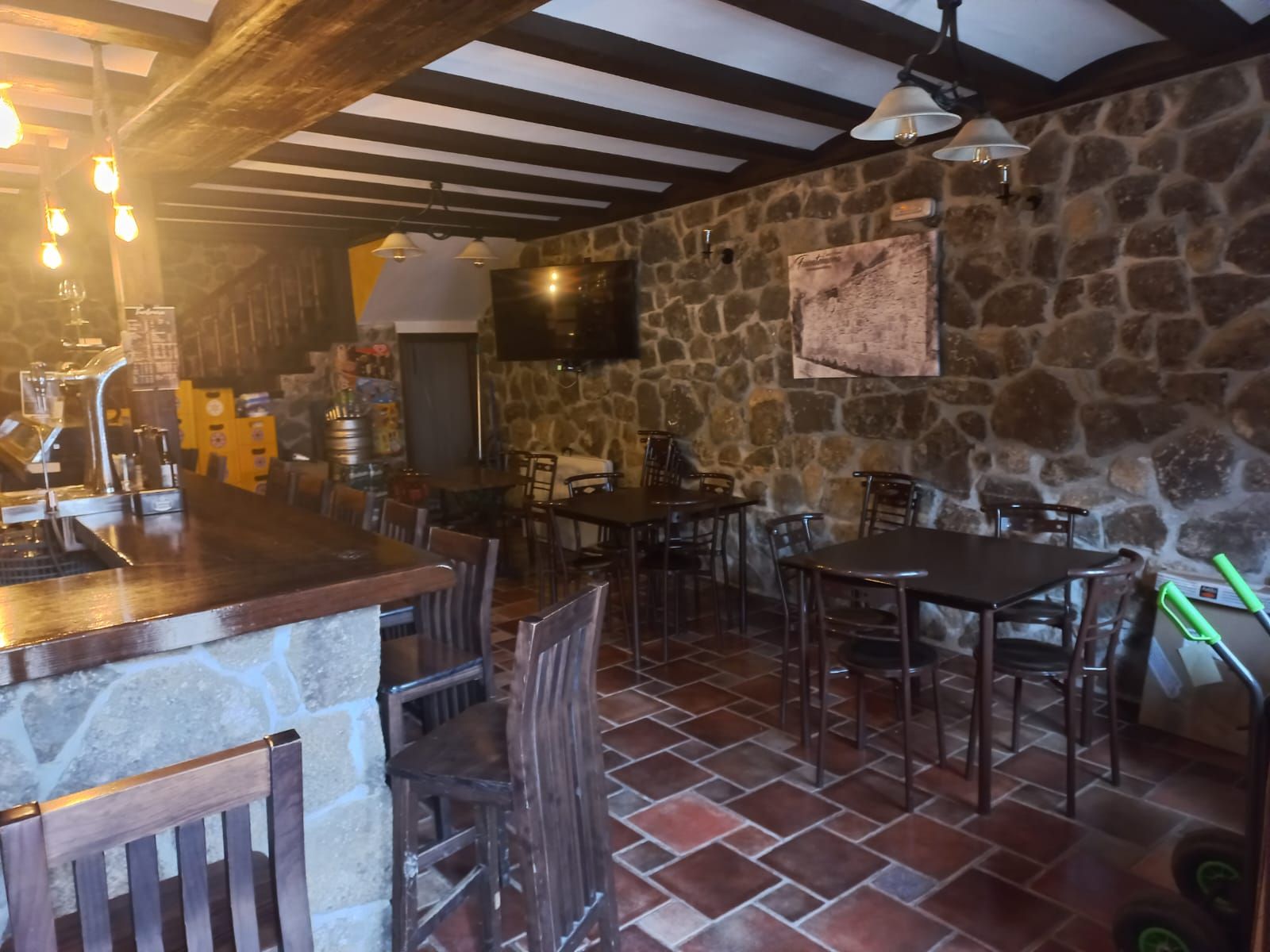 Un restaurante con mesas y sillas y una pared de piedra.