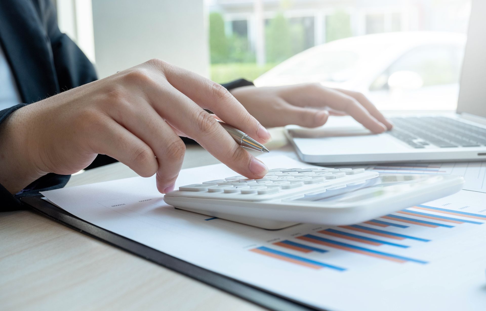 Calculette, mains et documents.