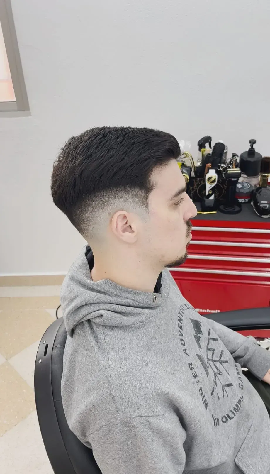 Perfil de una persona con un corte de pelo corto degradado 