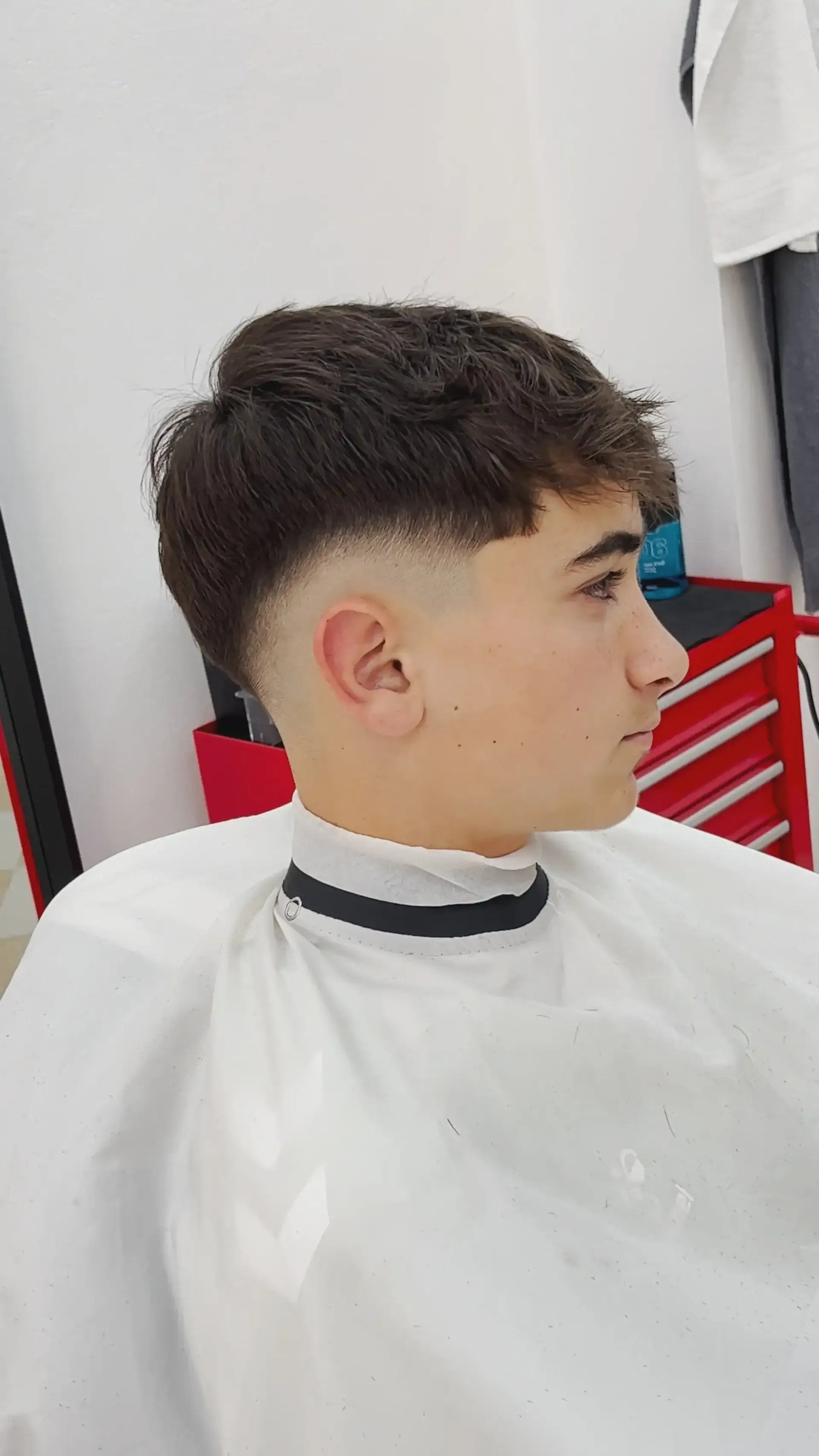 Perfil de una persona con un corte de pelo corto degradado