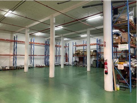 Un gran almacén con muchos estantes y un extintor de incendios.