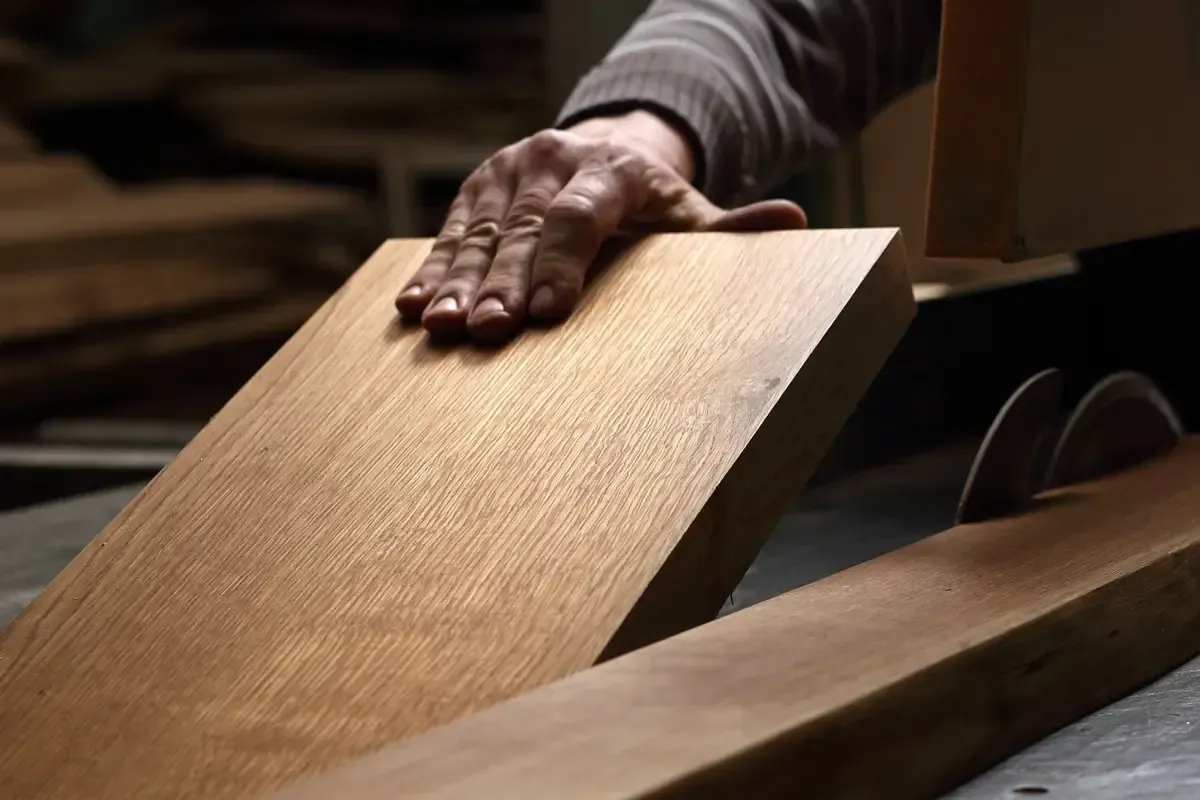 Das manuelle Glätten eines Holzbretts auf einer Sägewerksmaschine