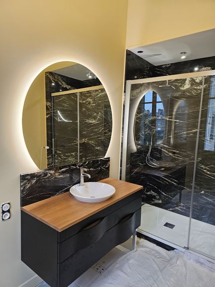 Salle de bains moderne avec baignoire en forme de croissant et grandes fenêtres.