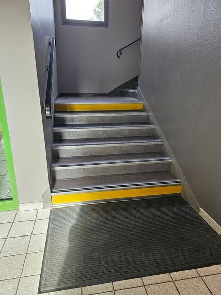 Personne posant un parquet, enfonçant un bloc contre une planche.