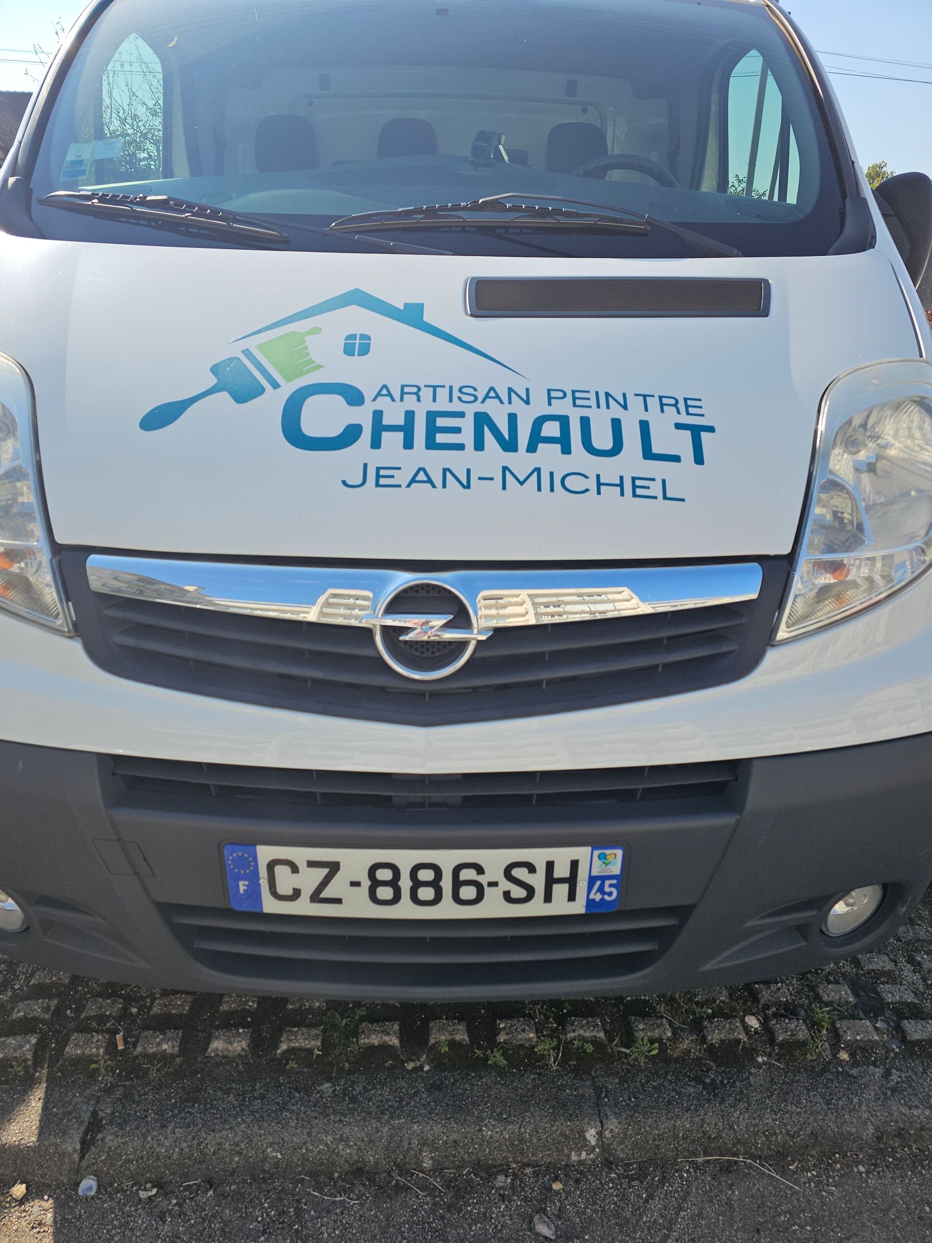 Fourgonnette Opel blanche avec logo de peintre artisanal CHENAUET à l'avant.