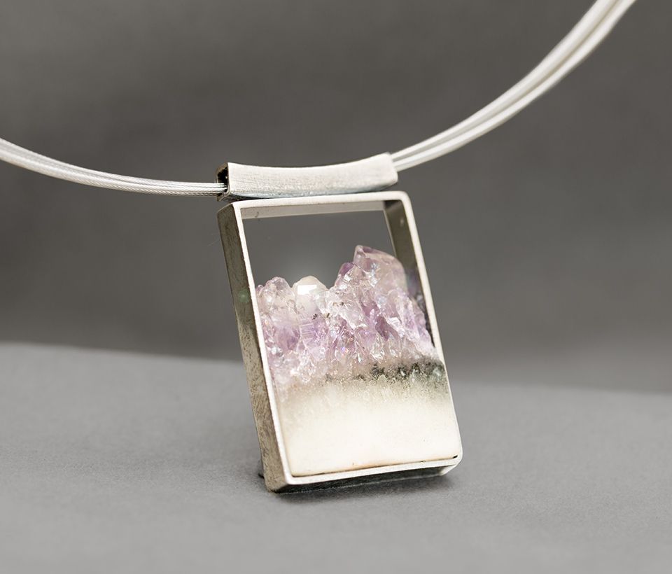 Silberne Halskette mit einem rechteckigen Anhänger mit violettem Amethyst.