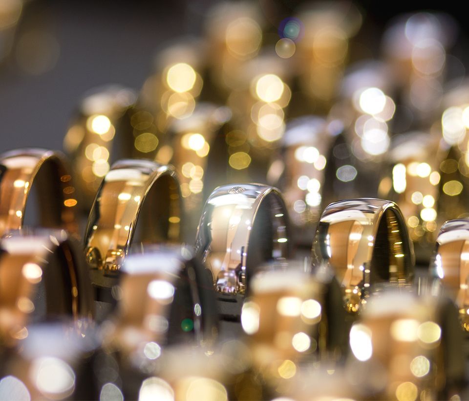 Goldene, silberne und schwarze Ringe in einem Juweliergeschäft, Nahaufnahme.