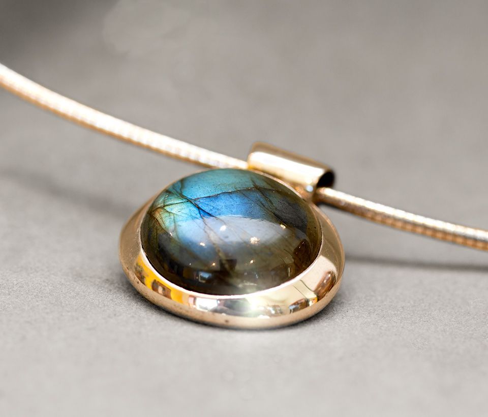 Goldene Halskette mit großem, schillerndem Labradoritstein.