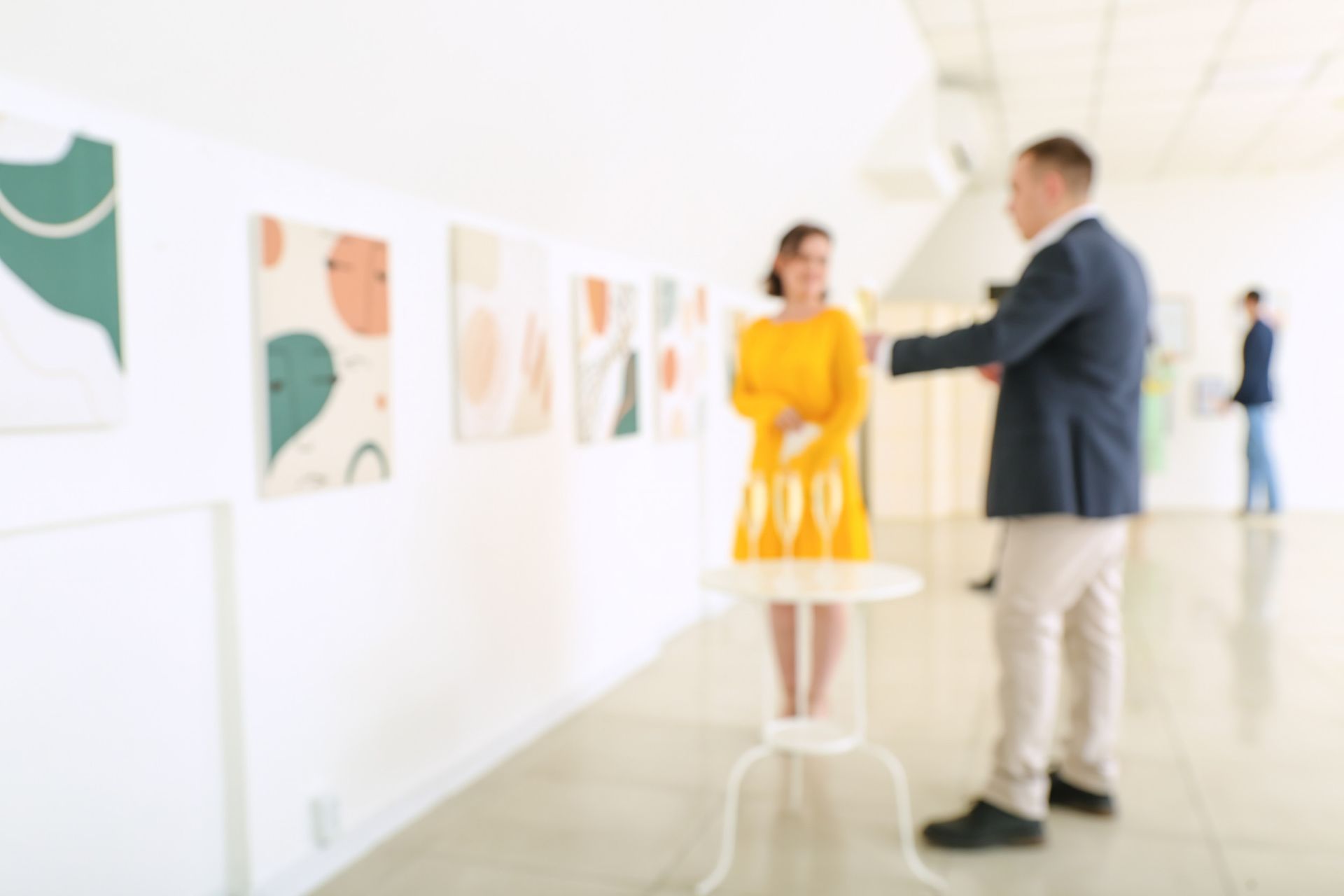 Un hombre y una mujer están mirando pinturas en un museo.
