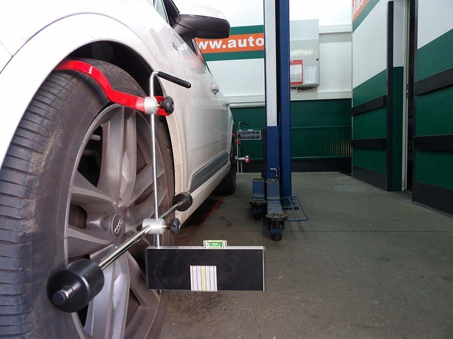 Ein weißes Auto steht in einer Garage von F&B Autoglas GmbH