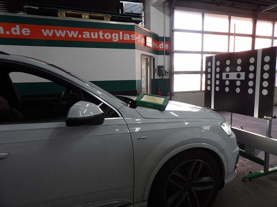 Ein weißes Auto steht in einer Garage von F&B Autoglas GmbH
