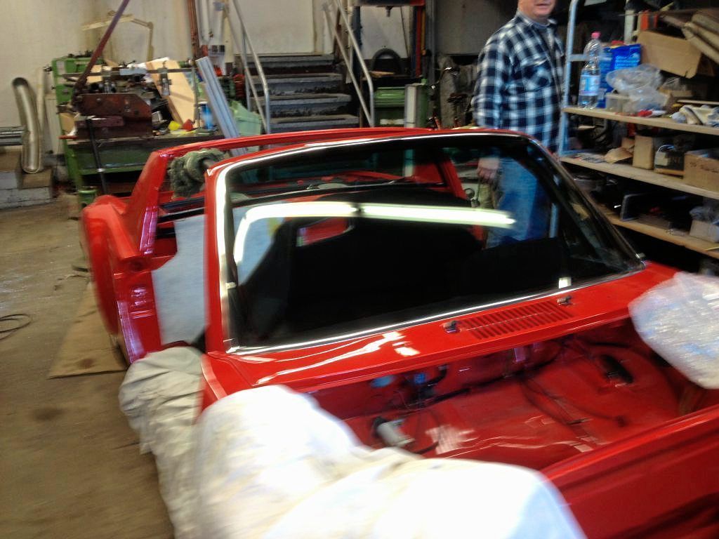 Ein rotes Auto steht in einer Garage bei der F&B Autoglas GmbH