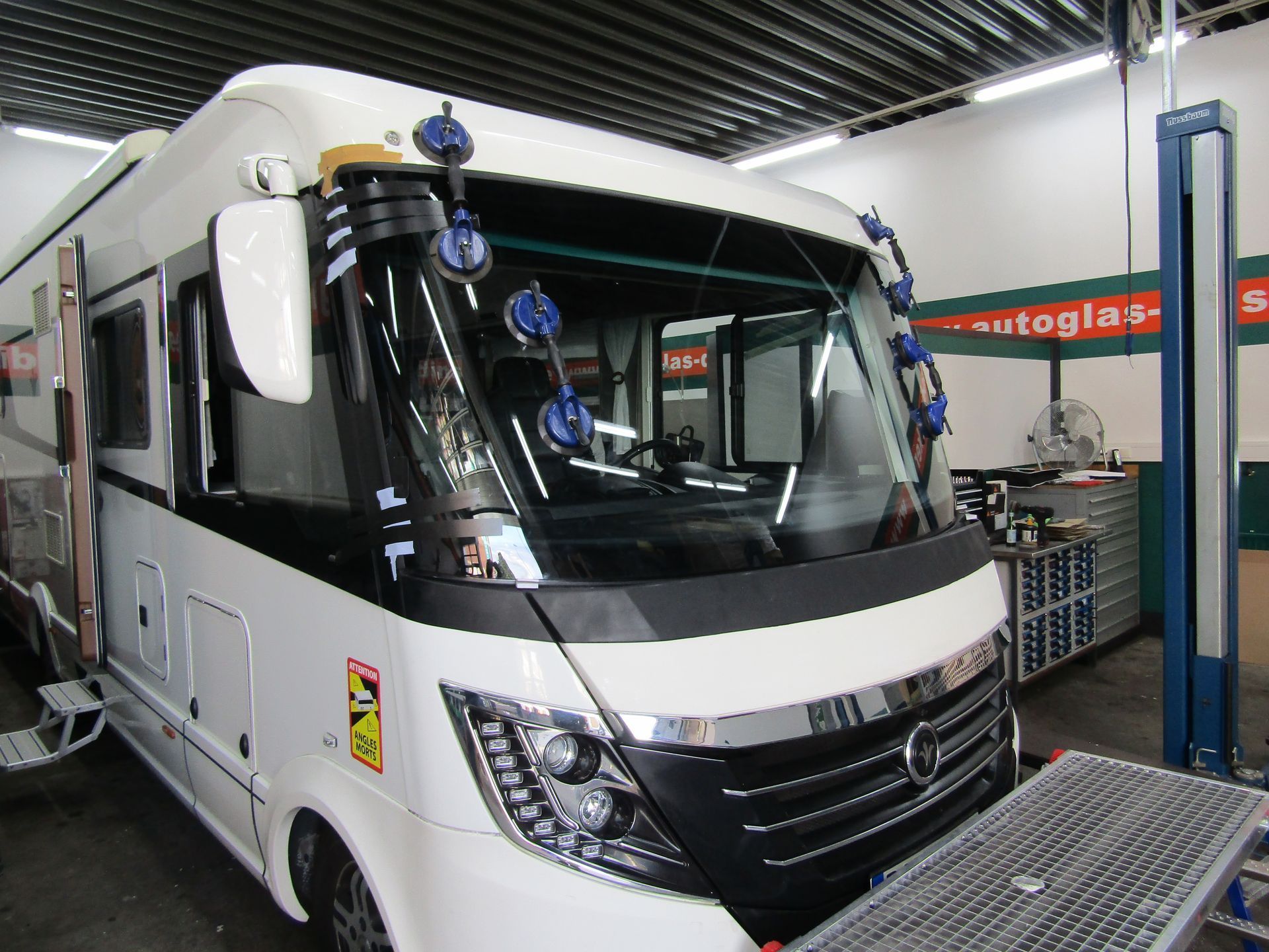 Ein weißes Wohnmobil steht in einem Autoglas-Zentrum